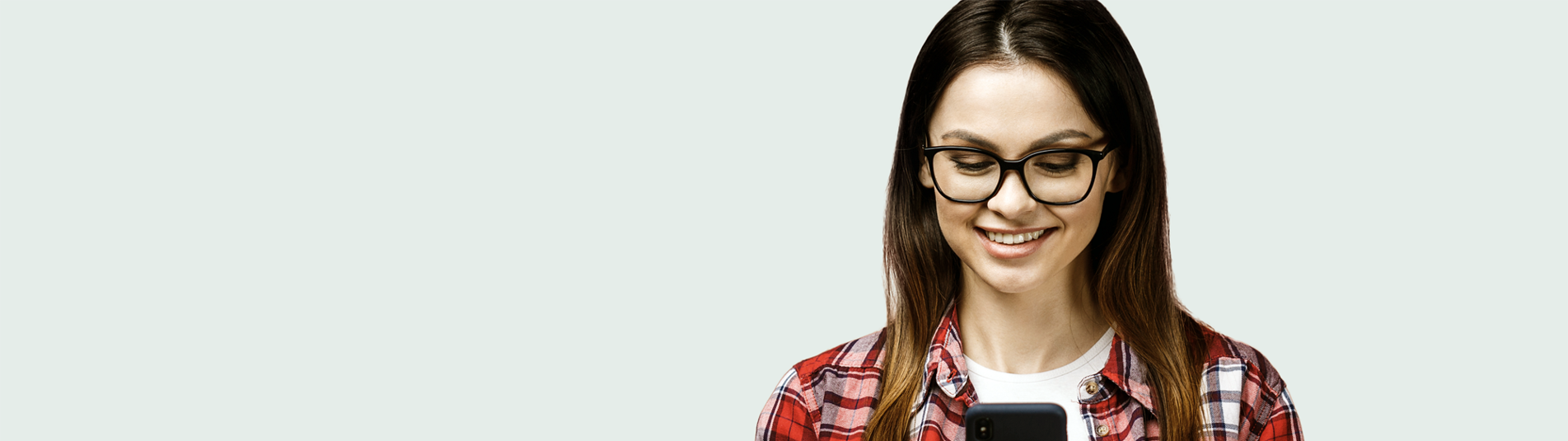 Smilende kvinde som kigger på sin smartphone